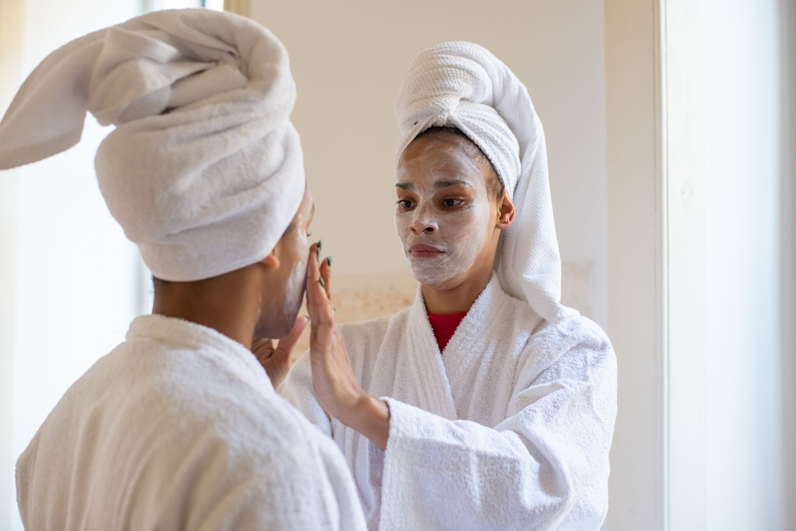 Uma mãe e filha desfrutando de um dia de spa relaxante com tratamentos faciais e roupões.